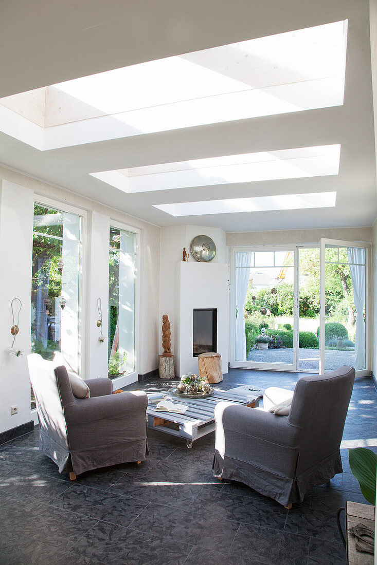 Living room with skylights and open terrace door leading into garden