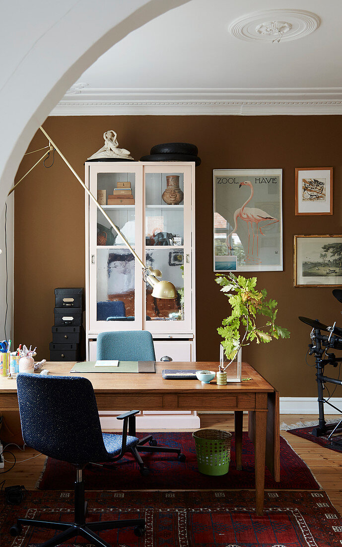 Desk in study with brown wall and white stucco ceiling