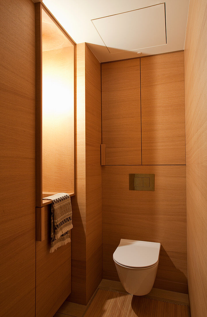 Wooden wall panelling and fitted cupboards in toilet