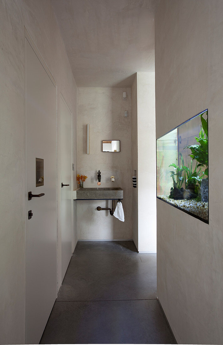 Flush-mounted aquarium in hallway with sink at far end