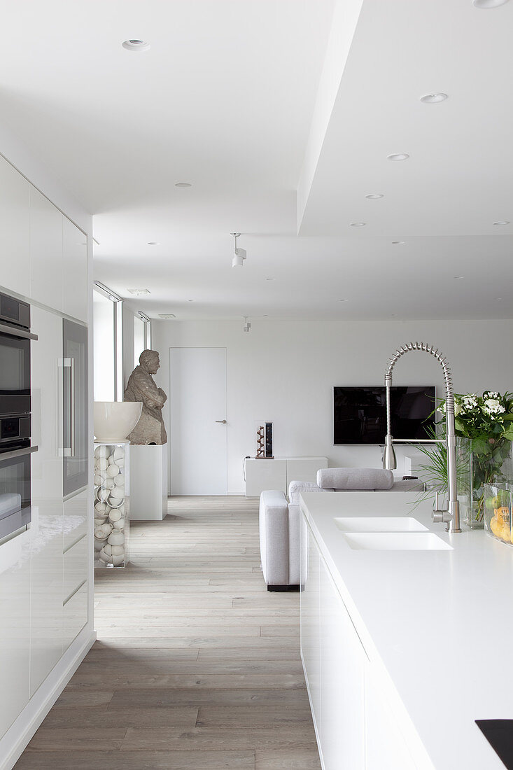 Blick von der offenen Küche in das moderne Wohnzimmer in Weiß