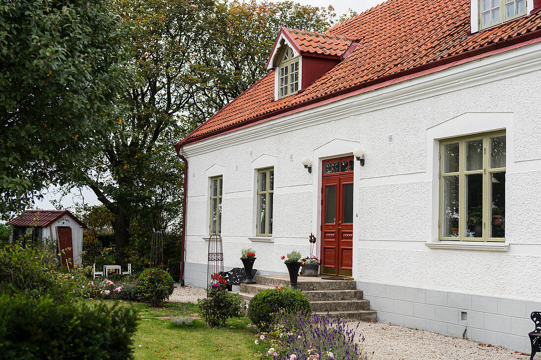 Klassisches Haus mit roter Haustür und Vorgarten