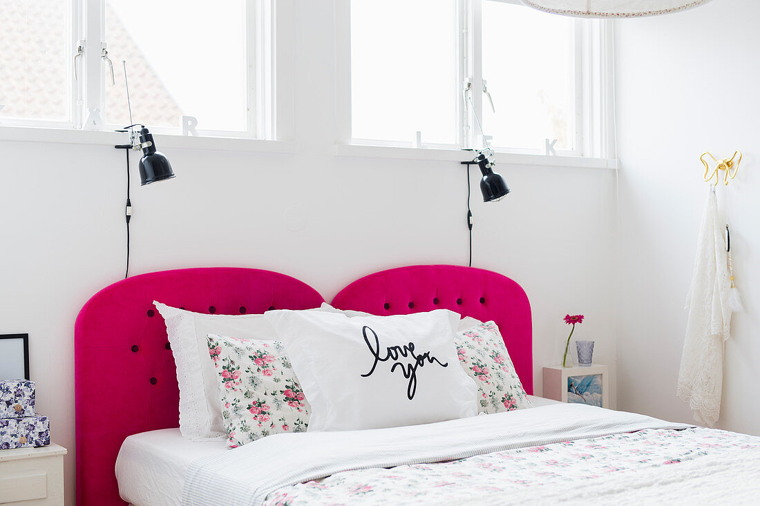 Doppelbett mit pinkfarbenem Kopfende in weißem Schlafzimmer