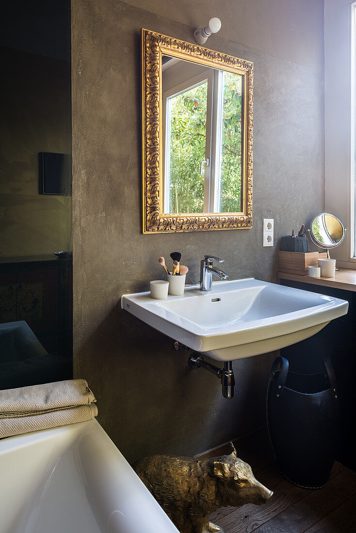 Waschbecken und Wandspiegel mit Goldrahmen im Badezimmer