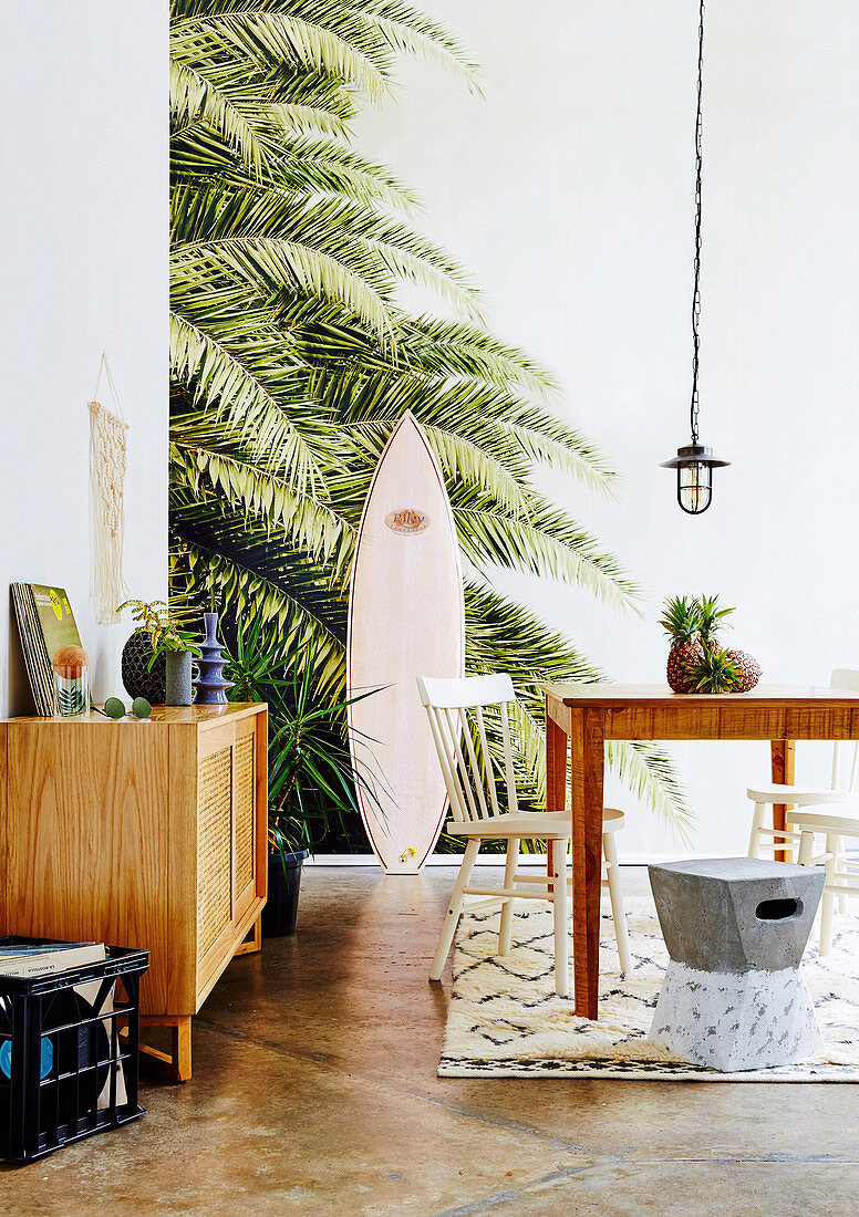 Dining room with beach feeling through palm tree wallpaper and surfboard