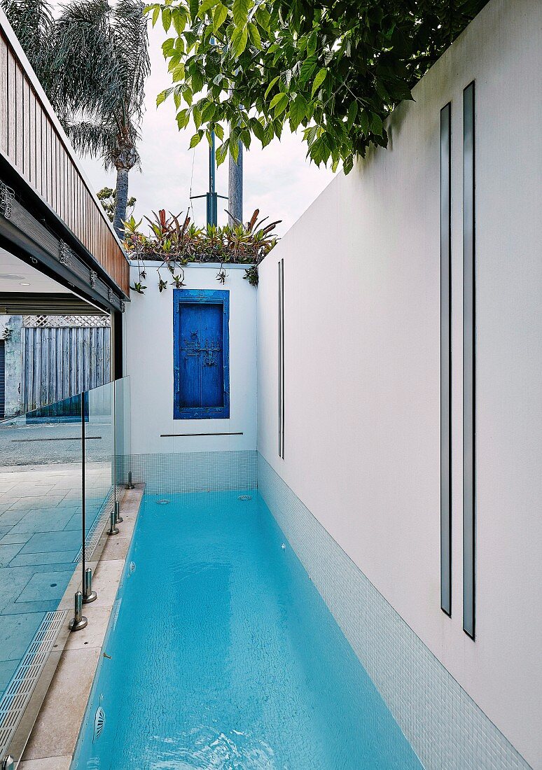 Langer schmaler Pool und eine blaue alte Tür