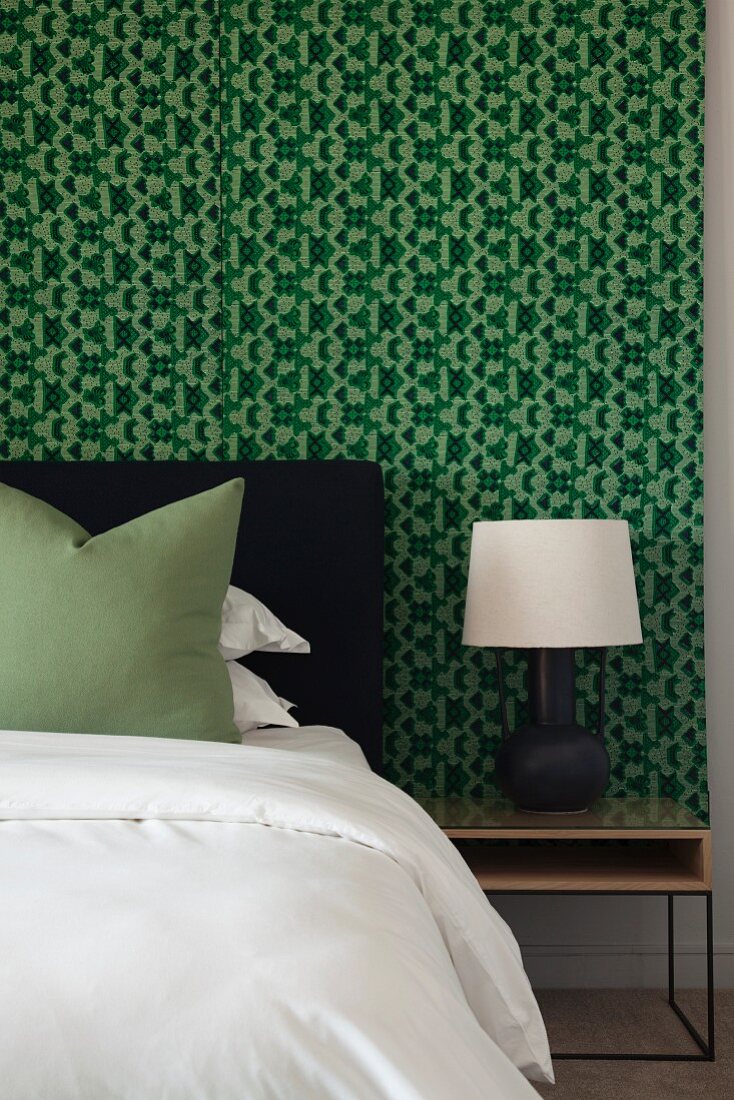 Bedroom with black, white and green colour scheme and wallpaper with graphic pattern