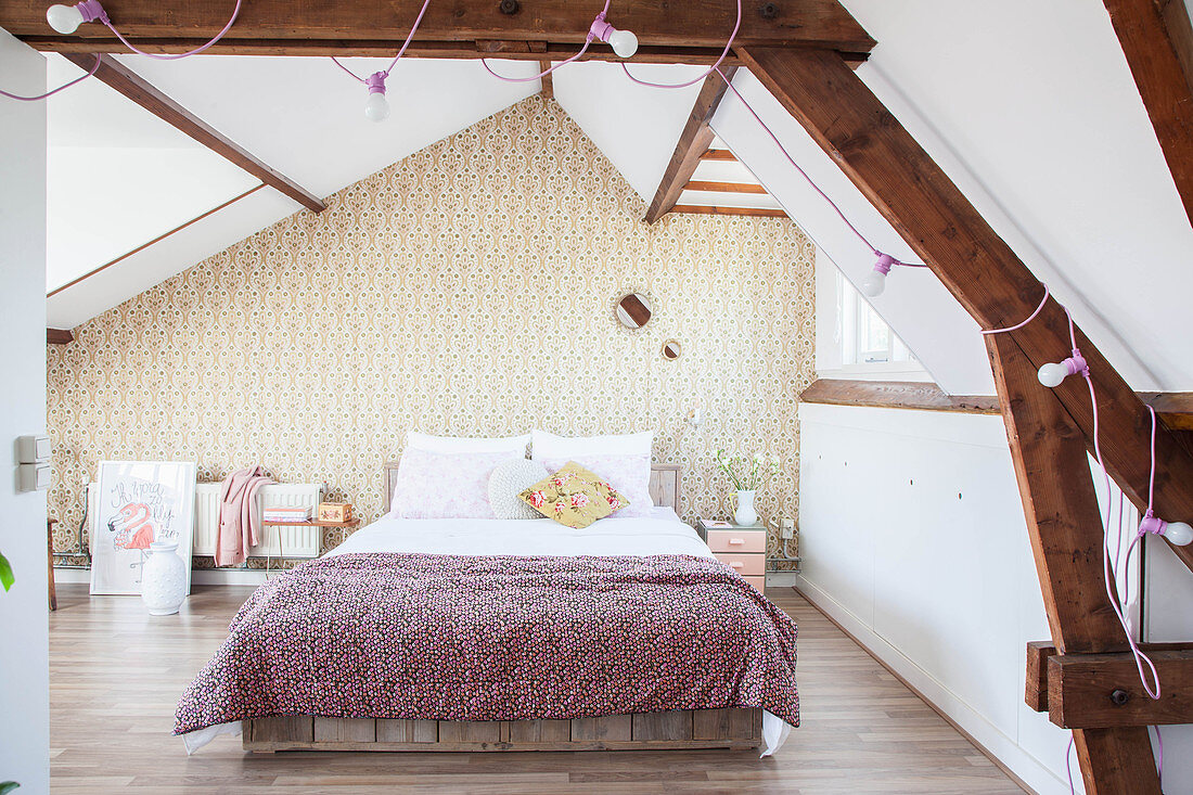 Schlafzimmer mit Doppelbett und Retro Tapete im Dachgeschoss