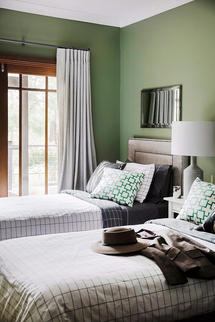 Two single beds in the guest room with green walls