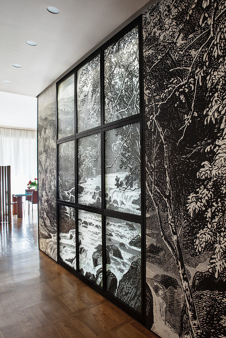 Zwischenwand mit schwarz-weißer Fototapete und Fensterrahmen in offenem Wohnraum
