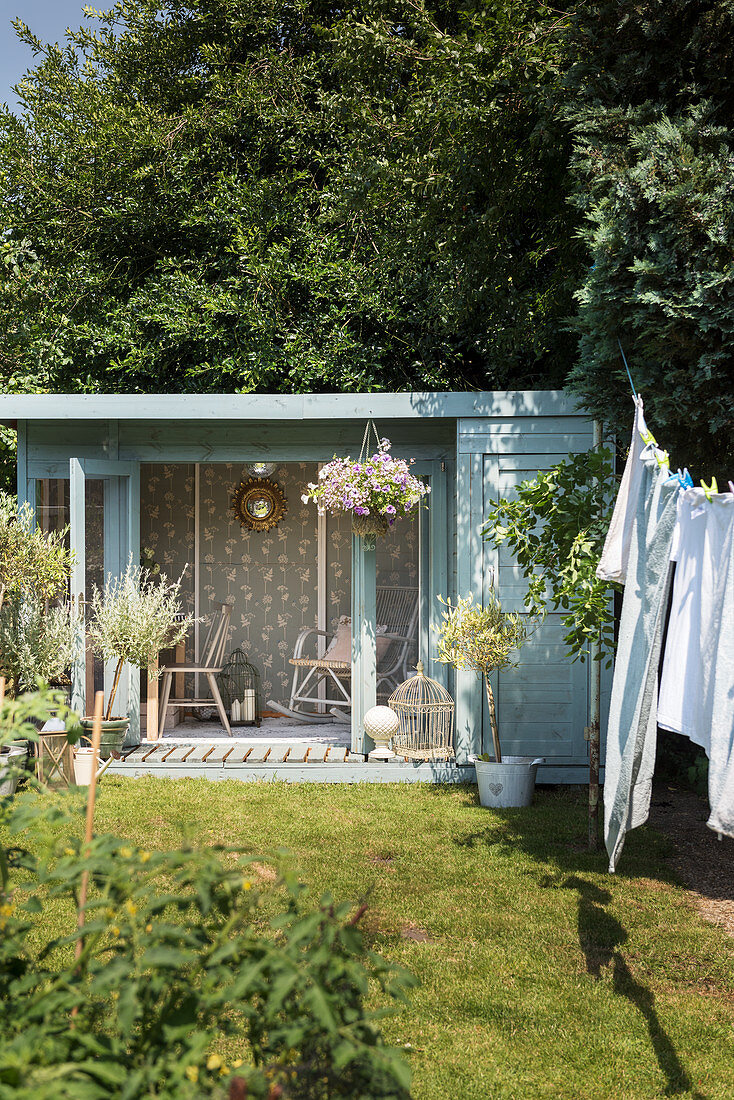 Laundry hung on washing line in garden with summerhouse in background