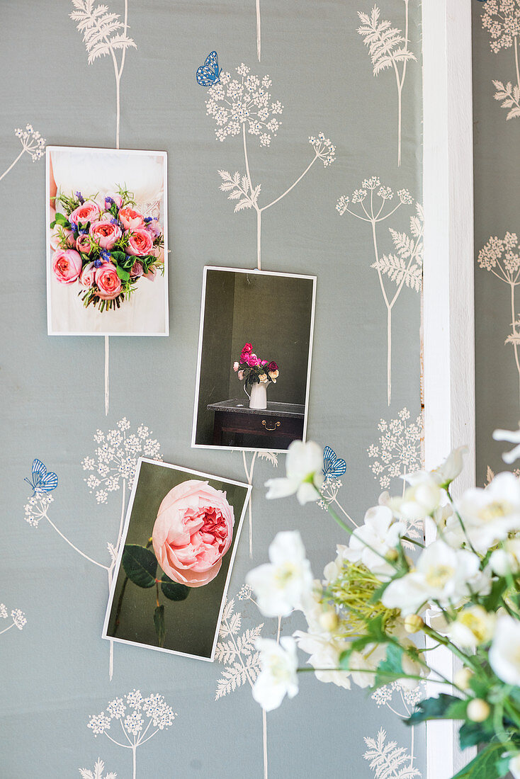 Postkarten mit Blumenmotiv an tapezierter Wand