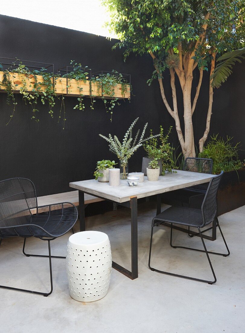 Modern garden furniture in courtyard with black wall