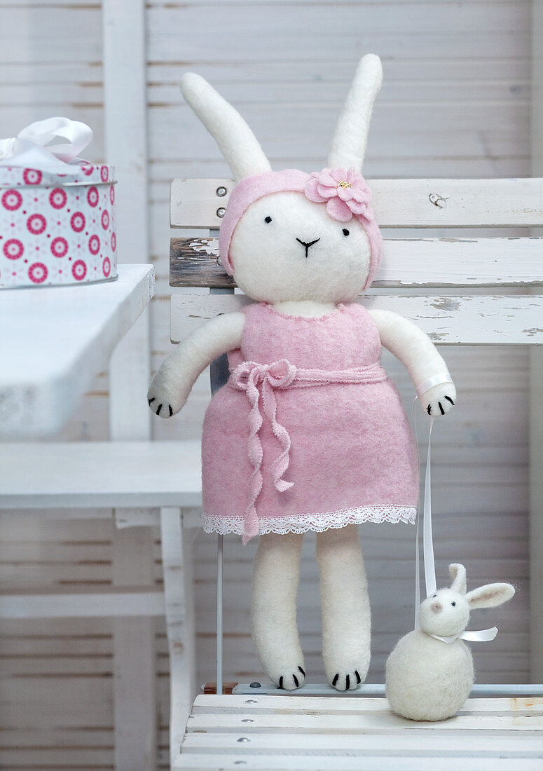 Hand-made, felt Easter bunny on white garden table