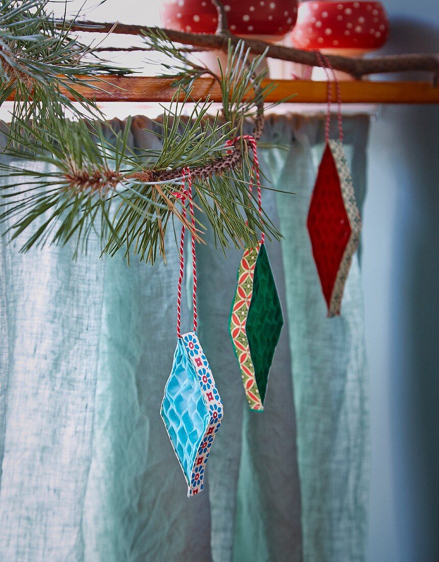 Corrugated paper diamonds with patterned edges hung from branch