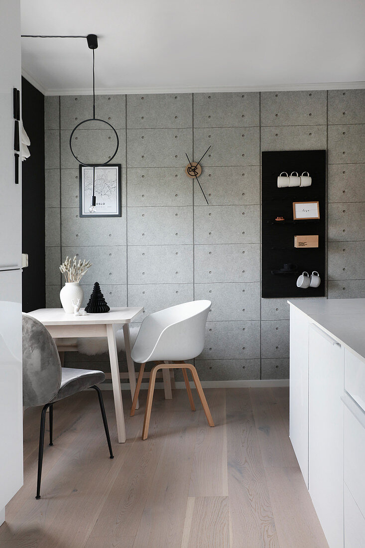 Tisch mit Stühlen in der Küchenecke mit graue Wand