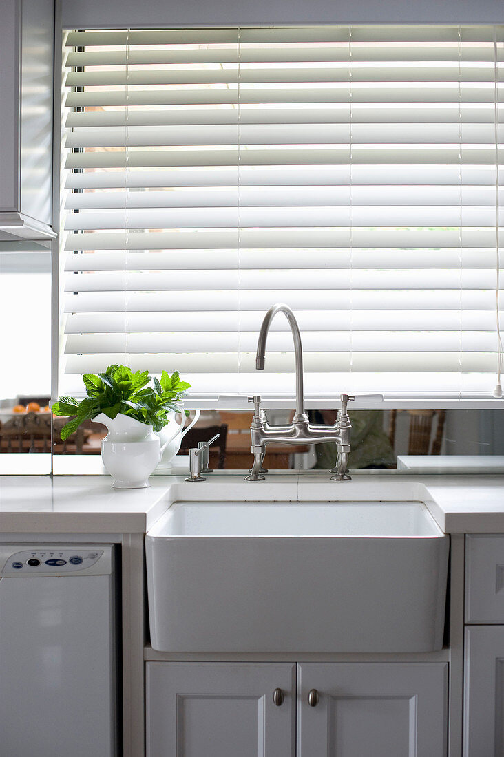 Küchenzeile mit Spülbecken vor Fenster mit geschlossener Jalousie