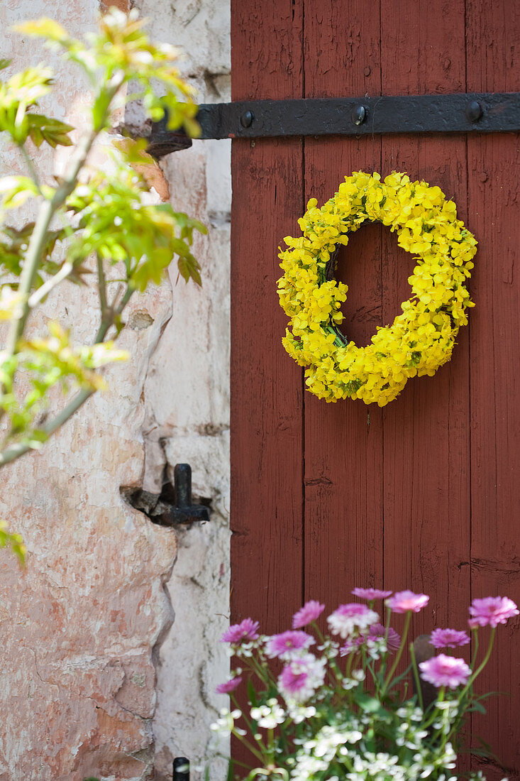 Wreath of yellow flwoers on red barn door
