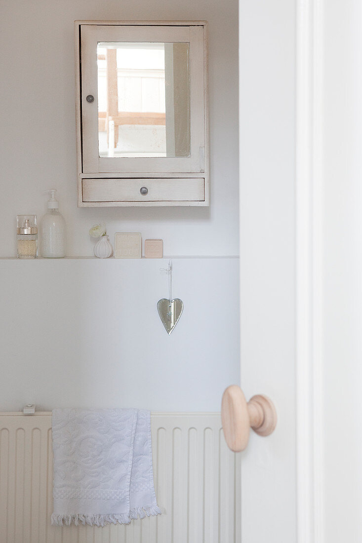 Blick in weißes Badezimmer mit Wandschränkchen