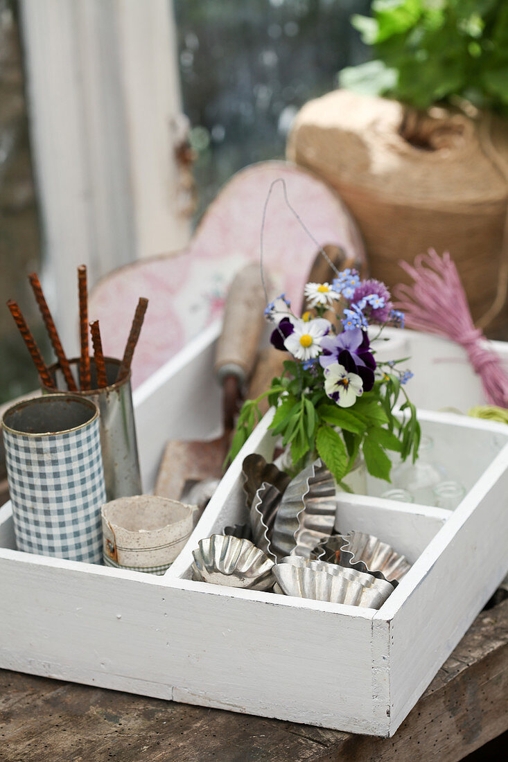 Posy of spring flowers and craft materials in organiser crate