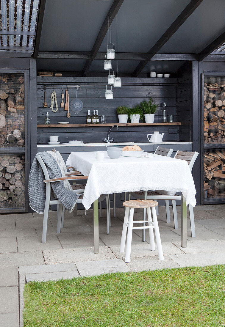 Dining area and outdoor kitchen in grey on roofed terrace