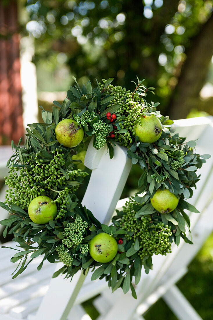 Wreath of green apples and unripe elderflowers