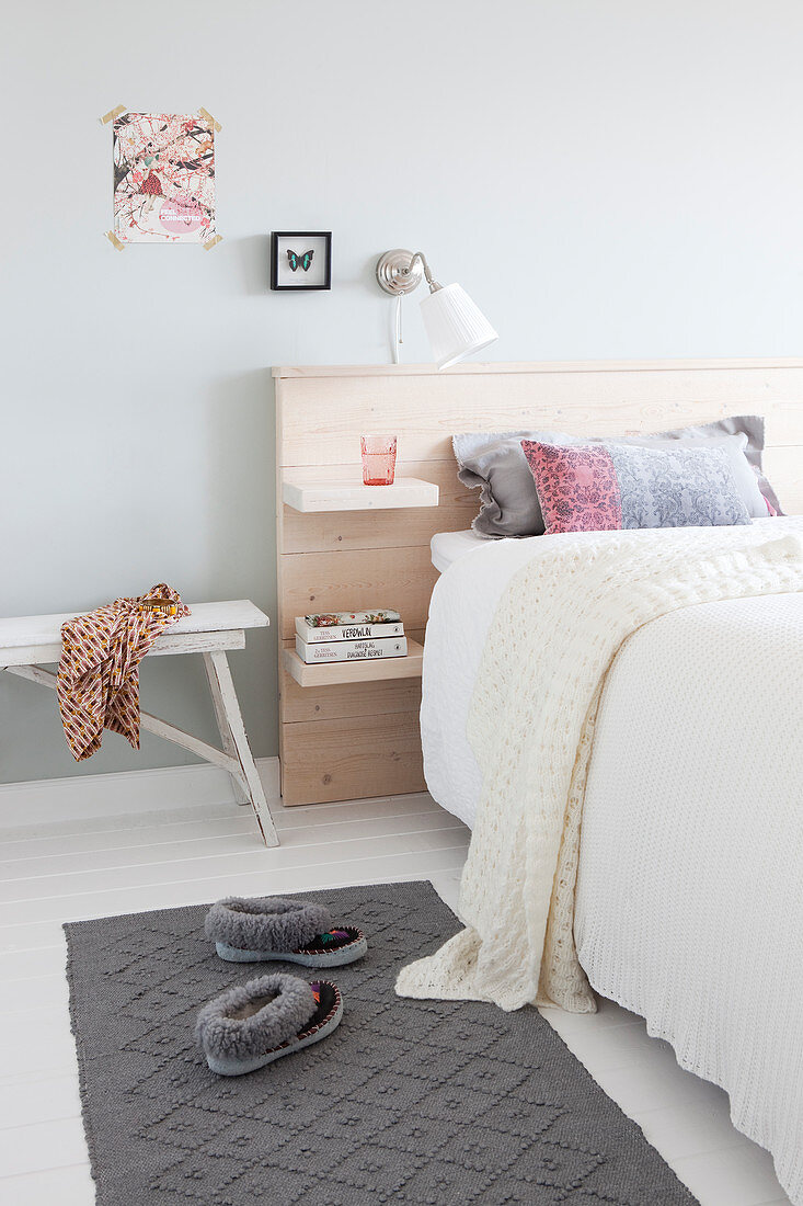 Doppelbett mit Bettkopfteil aus Holz in hellem Schlafzimmer
