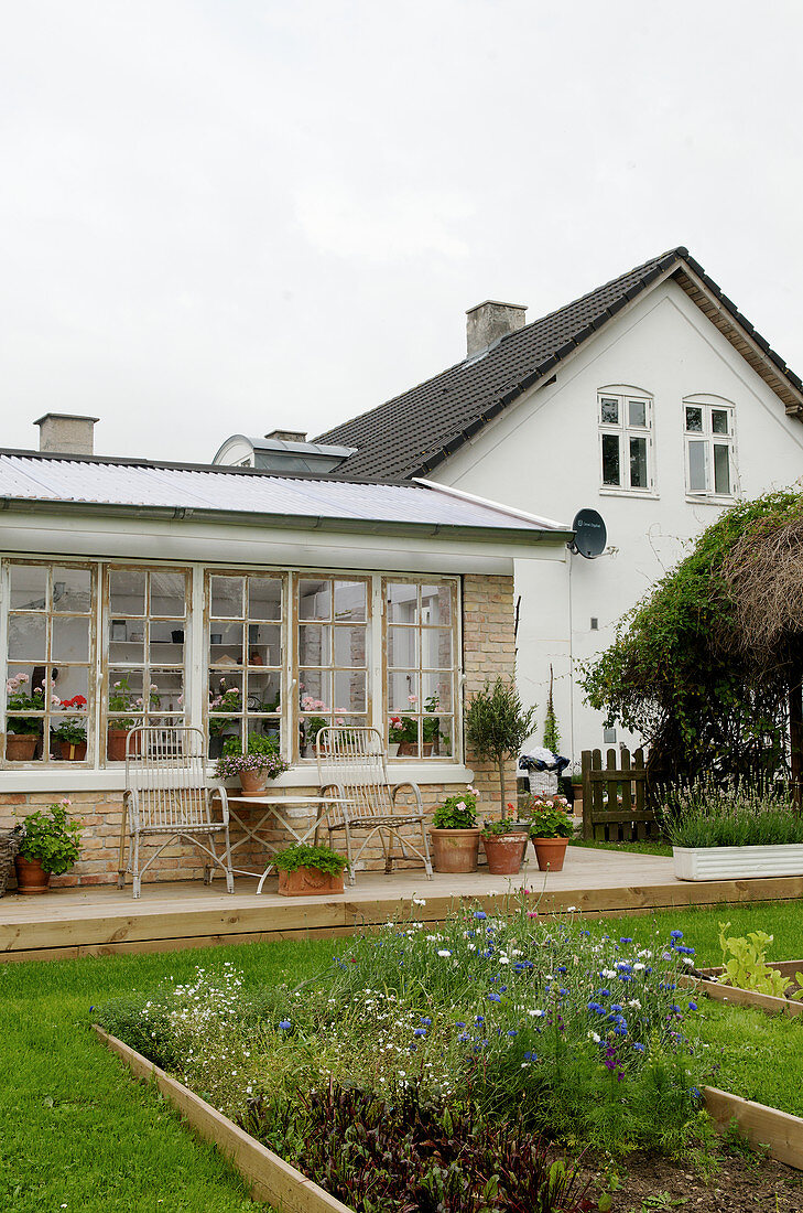 Terrasse am Wintergarten mit Sprossenfenstern, Beete im Garten