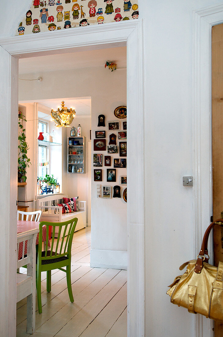 Blick ins Esszimmer mit grünem Sprossenstuhl und Bildergalerie
