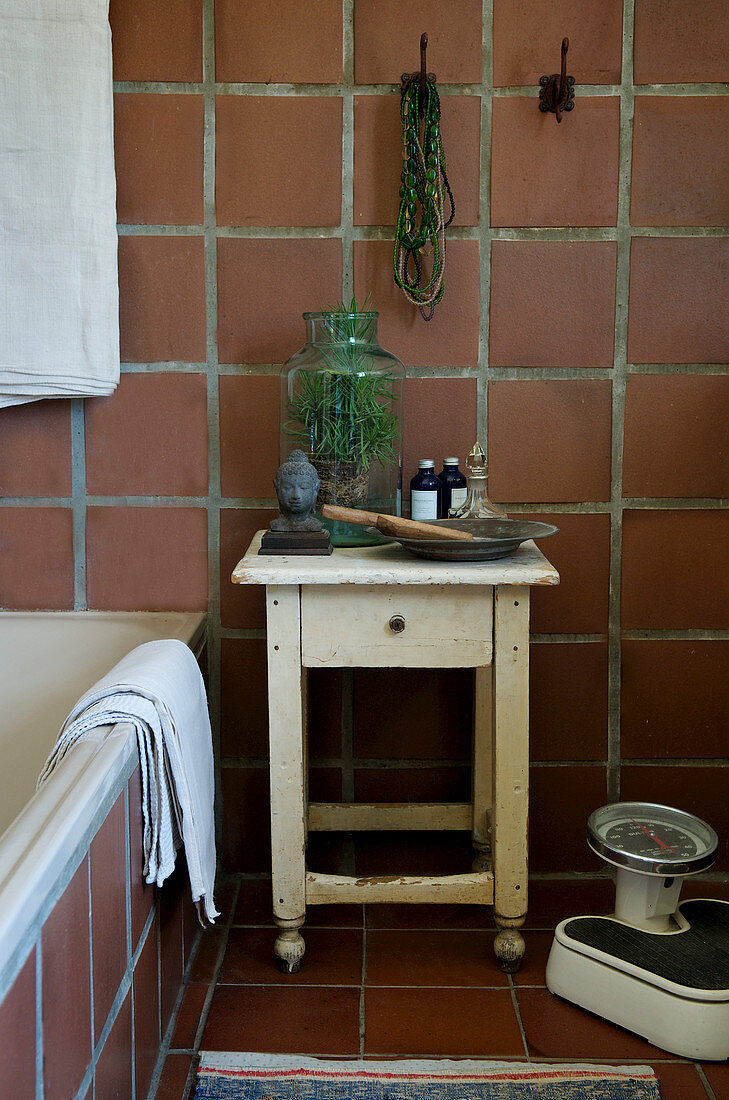 Old stool with drawer in bathroom with terracotta tiles