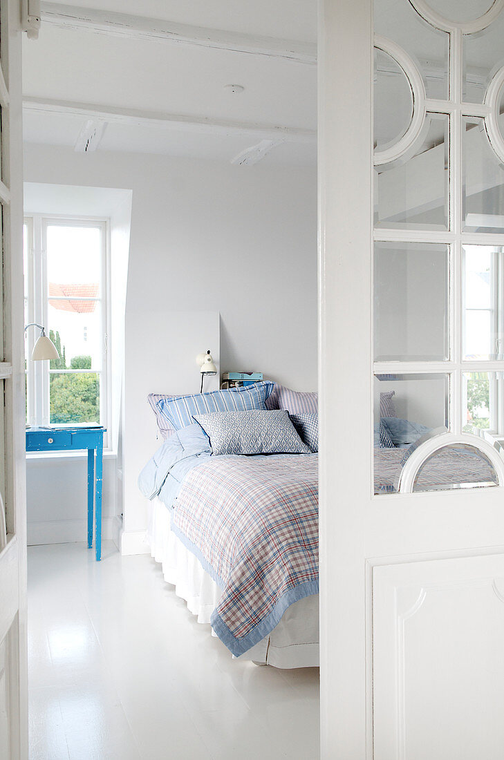 Glastür zum Schlafzimmer mit weißem Boden und blauen Farbakzenten