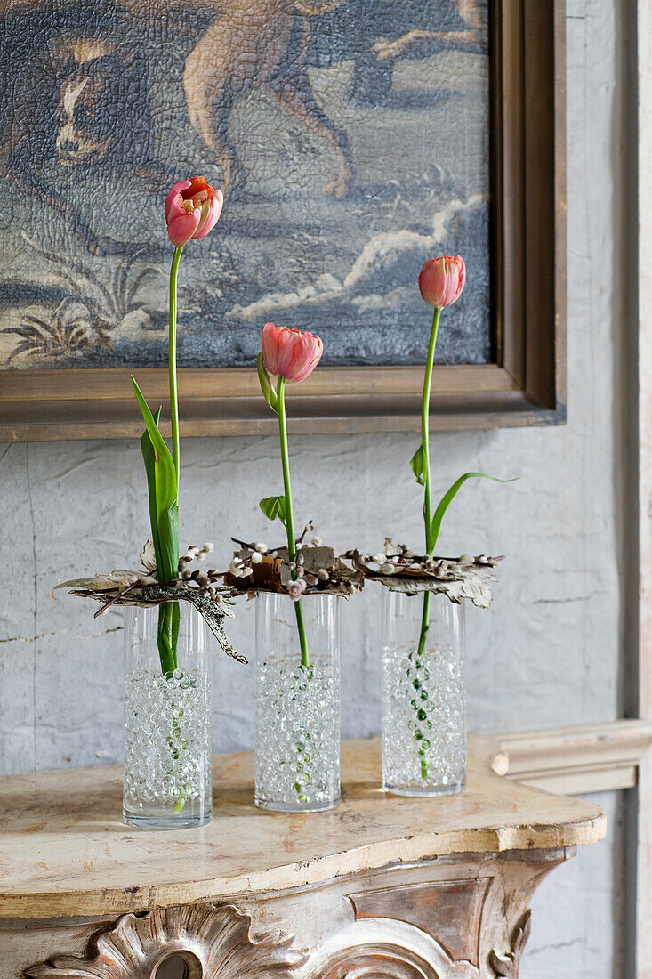 Tulips decorated with birch bark and willow catkins in glass vases