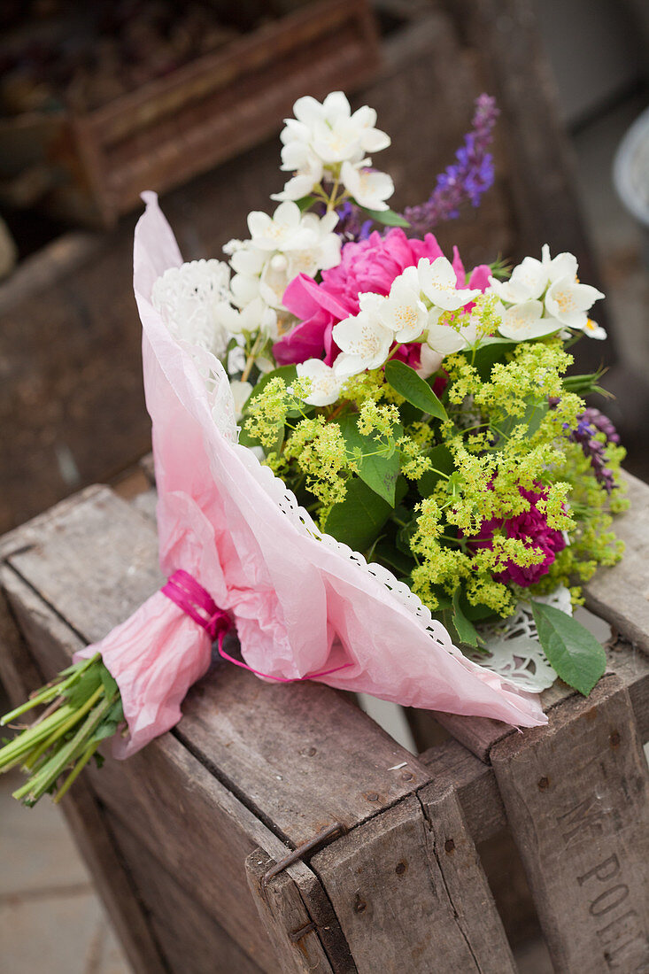 Blumenstrauß mit Pfingstrosen, Frauenmantel und Bauernjasmin mit Papiermanschette
