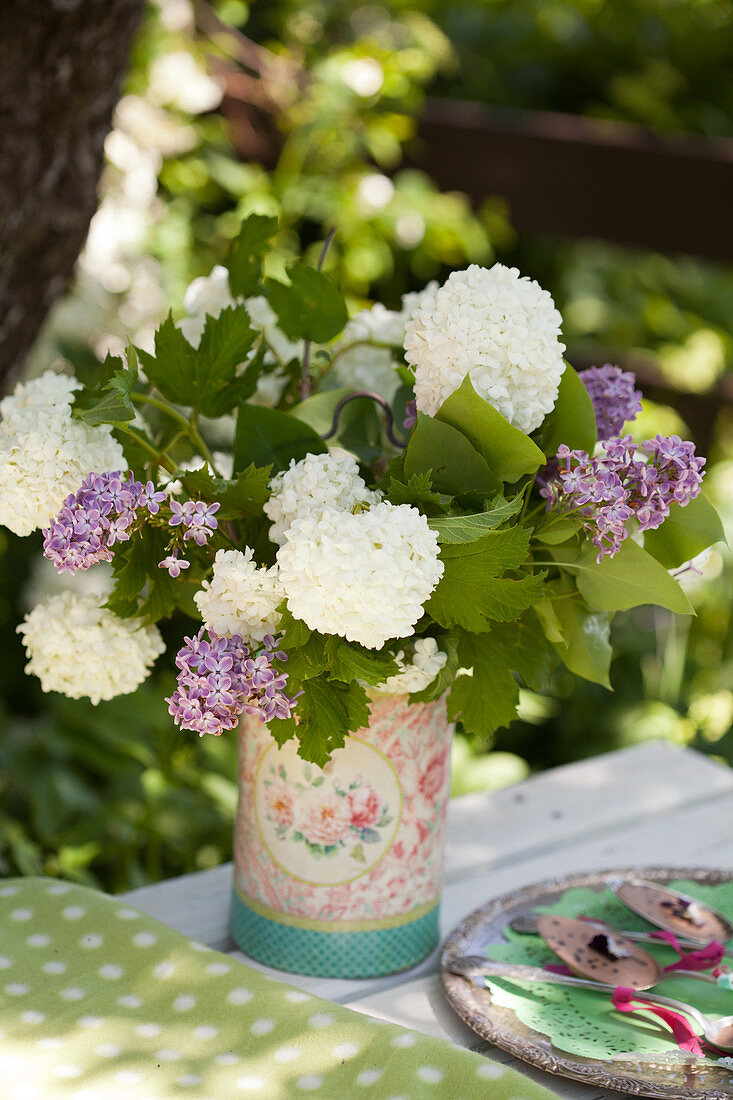 Blumenstrauß mit Schneeball und Flieder in nostalgischer Vase