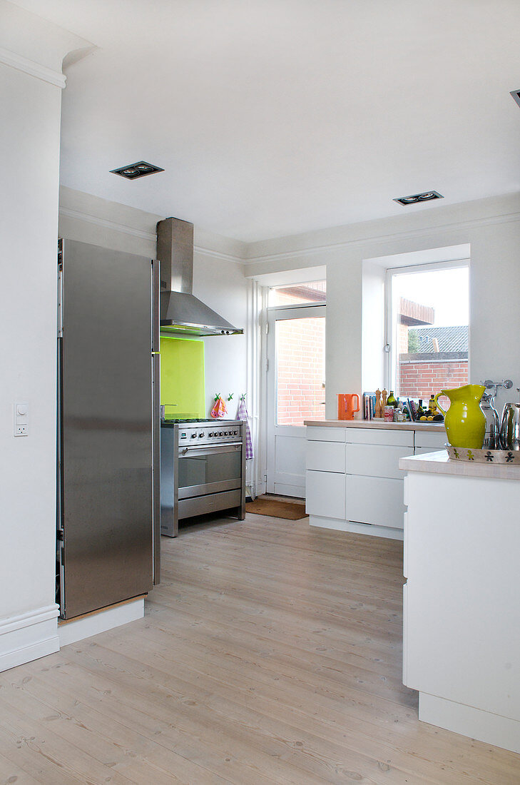 Moderne Küche mit hellem Holzboden und Edelstahl-Geräten