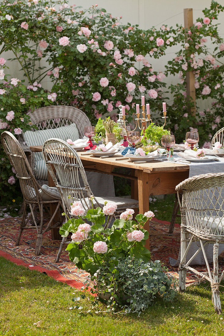 Festlich gedeckter Tisch auf einem Teppich im sommerlichen Garten