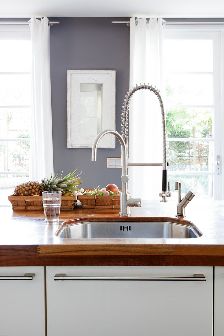 Sink with flexible tap in kitchen with wooden worksurface