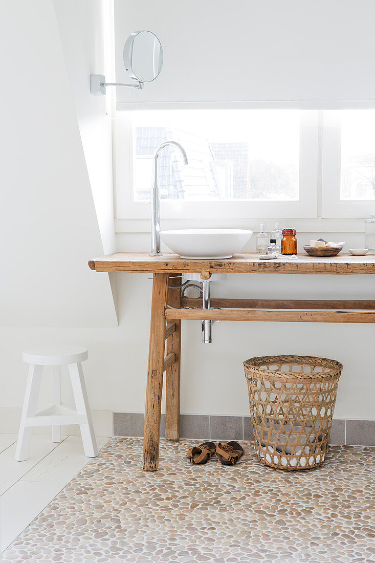 Twin sinks on rustic wooden table in white bathroom