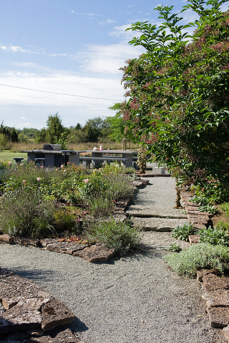 Stone bordered flower beds with paths of gravel in the garden