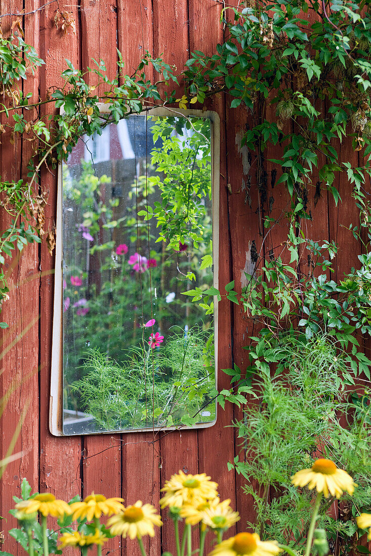 Spiegel an Holzwand im Garten