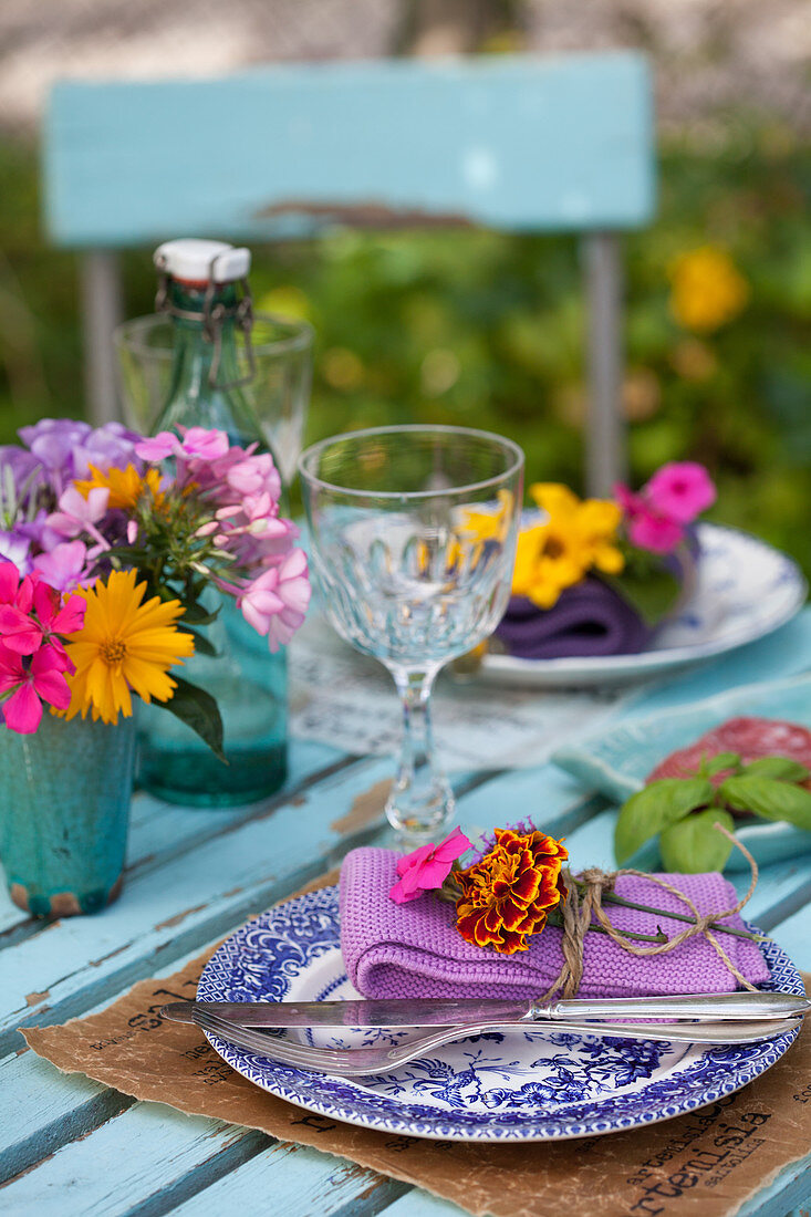 Mit Sommerblumen gedeckter Tisch im Garten