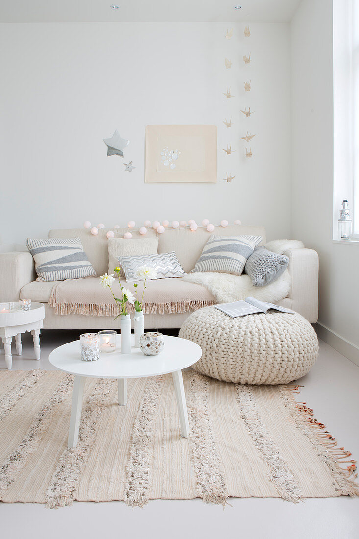 Couch mit Kissen, Tischchen und Sitzsack in weihnachtlich dekoriertem, weißem Wohnzimmer