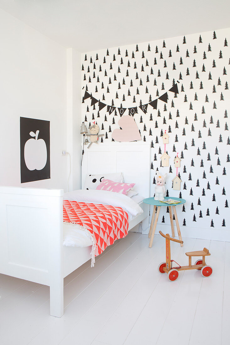 Nordisches Kinderzimmer mit weißem Bett und schwarz-weißer Tapete