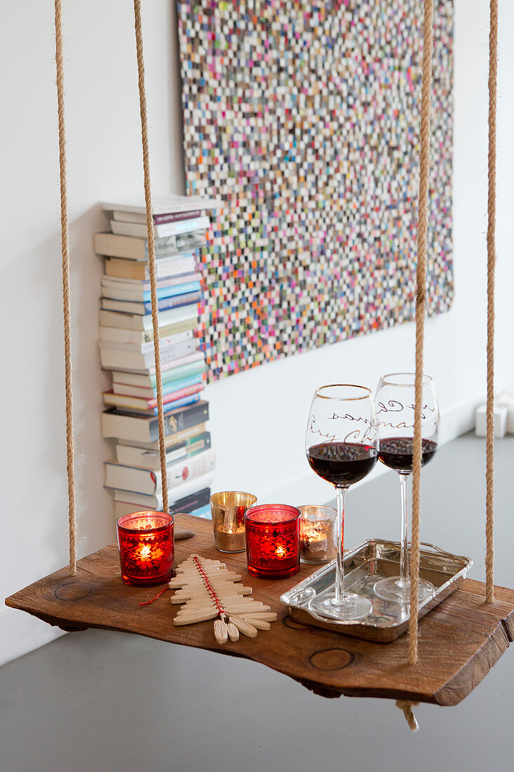 Christmas decorations on small DIY table made from wooden plank and ropes