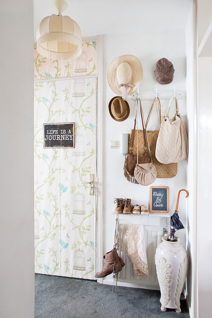 Vintage-style wallpaper on door and old-fashioned accessories in hallway
