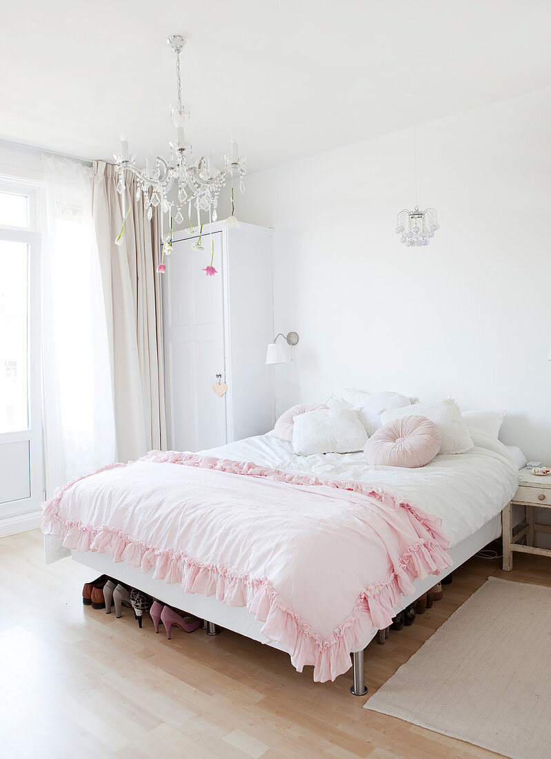 Rosafarbene Rüschendecke auf dem Bett im Schlafzimmer in Weiß