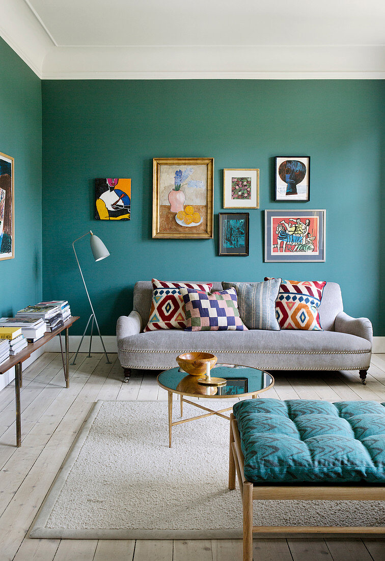 Bildergalerie überm Sofa im Wohnzimmer mit petrolblauen Wänden