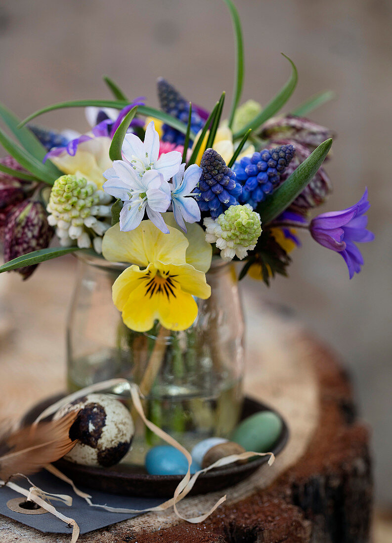 Colorful Easter bouquet of different spring flowers in a glass