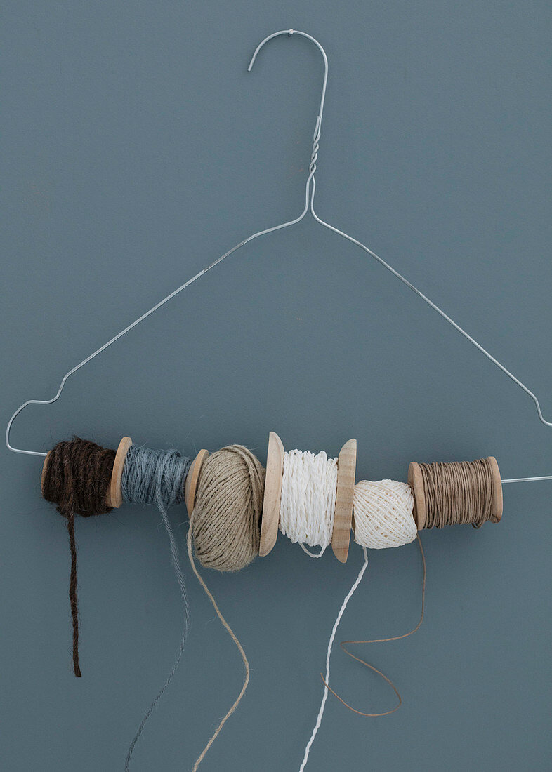 Wire coat hanger for storing twine and spools of thread