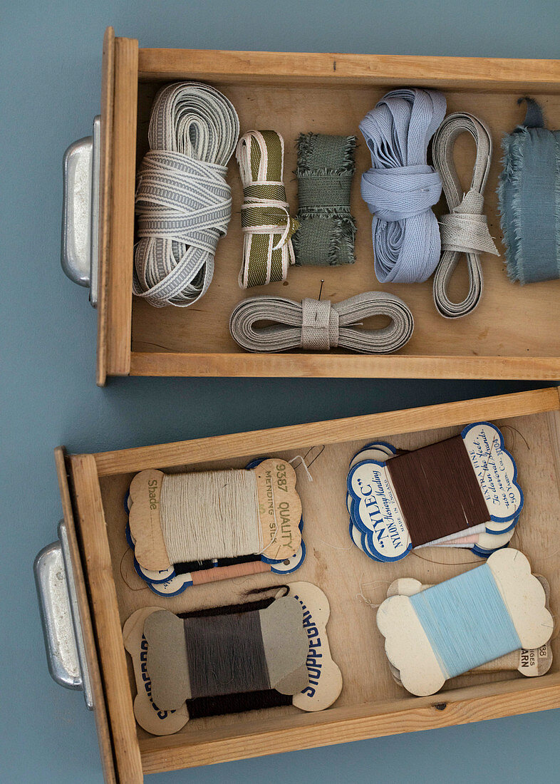 Fabric ribbons and old sewing thread in wooden drawers